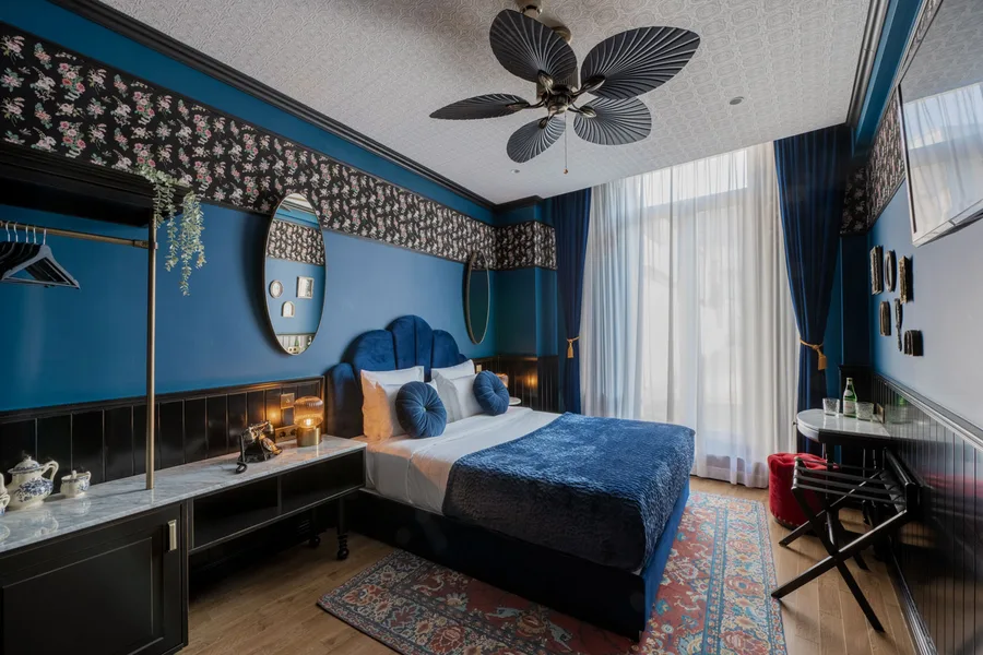 A double hotel room with a blue velvet bed